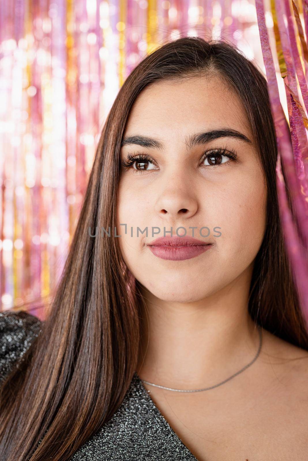 New Year party celebration.Closeup of woman in glitter dress standing on glitter purple and gold background