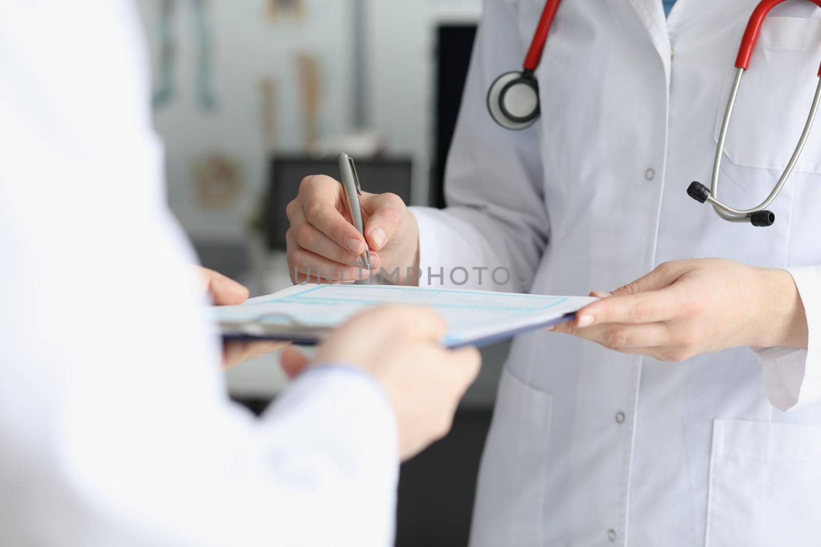 Doctor in medical gown put sign on clipboard with prescription paper by kuprevich