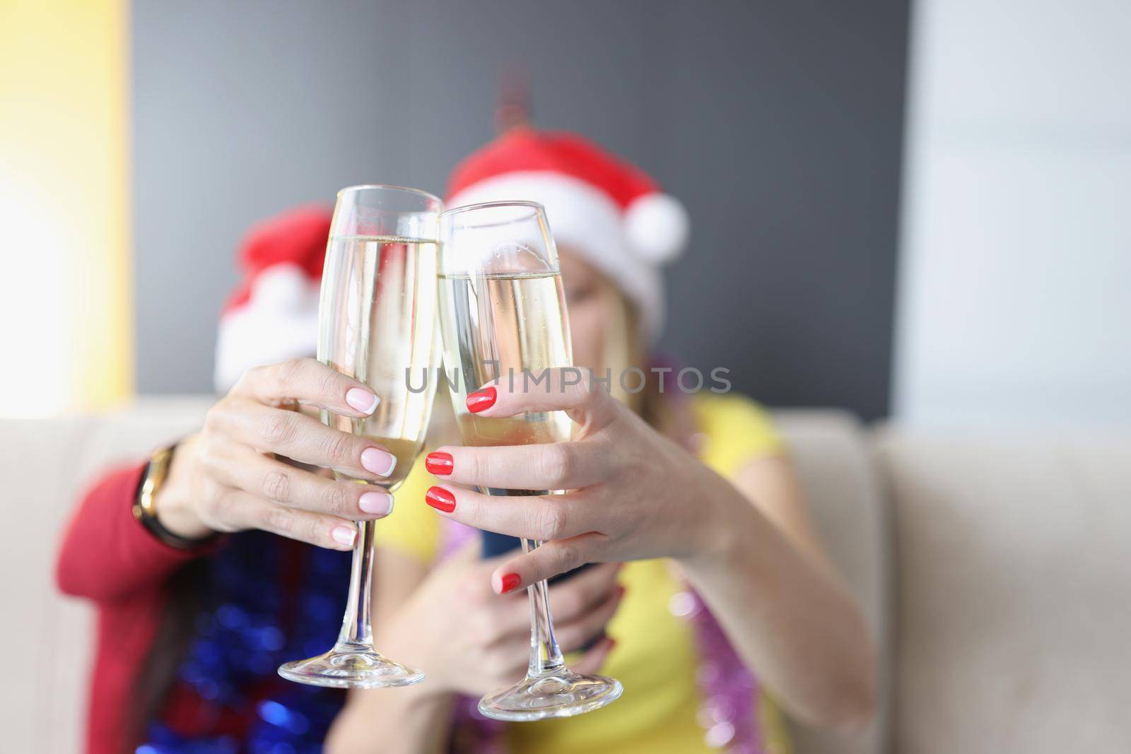Women hold champagne drinks, glass filled with alcohol, raise toast for new year coming by kuprevich