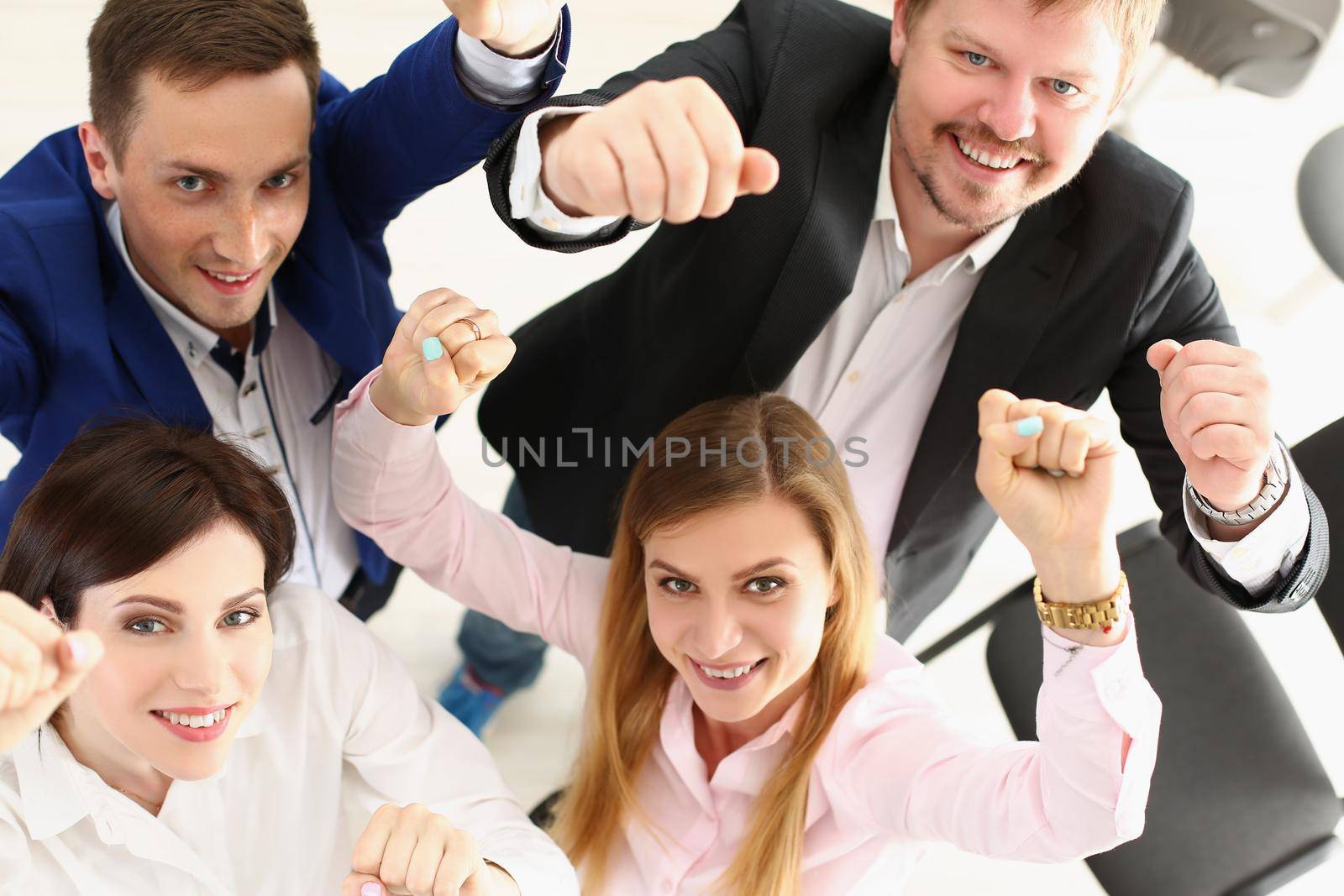 Top view of group of people show support gesture collectively in office. Well dressed workers posing with smile, cheerful mood. Business, teamwork concept