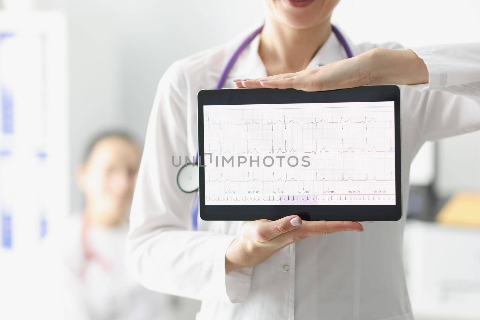 Doctor showing digital tablet screen with heart cardiogram result by kuprevich