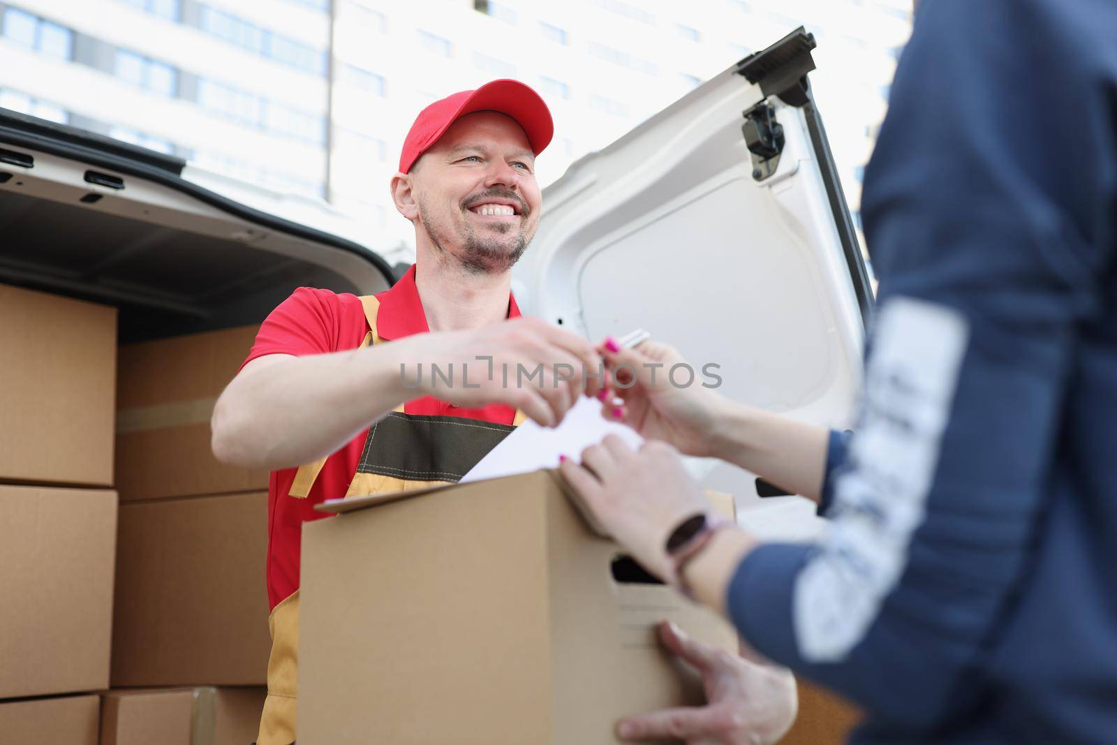 Portrait of courier and receiver make trade with signature on document for order. Worker delivered box fast on personal address. Delivery service concept