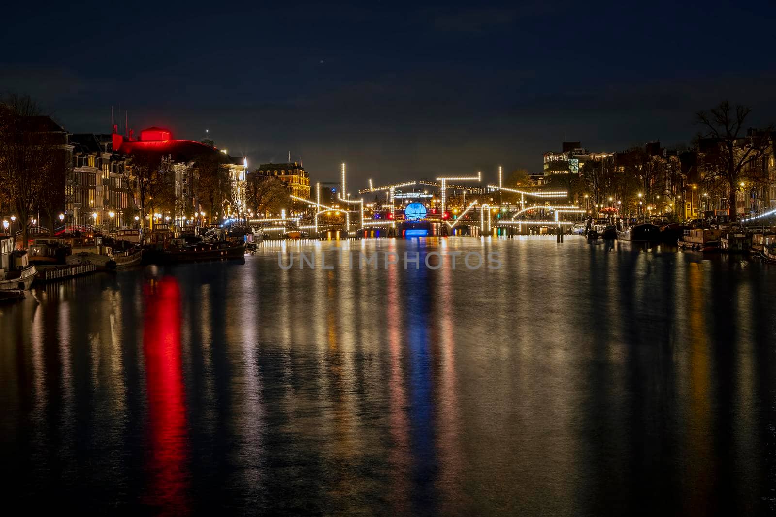 Amsterdam by night with the illuminated Tiny Bridge at the Amstel in the Netherlands by devy