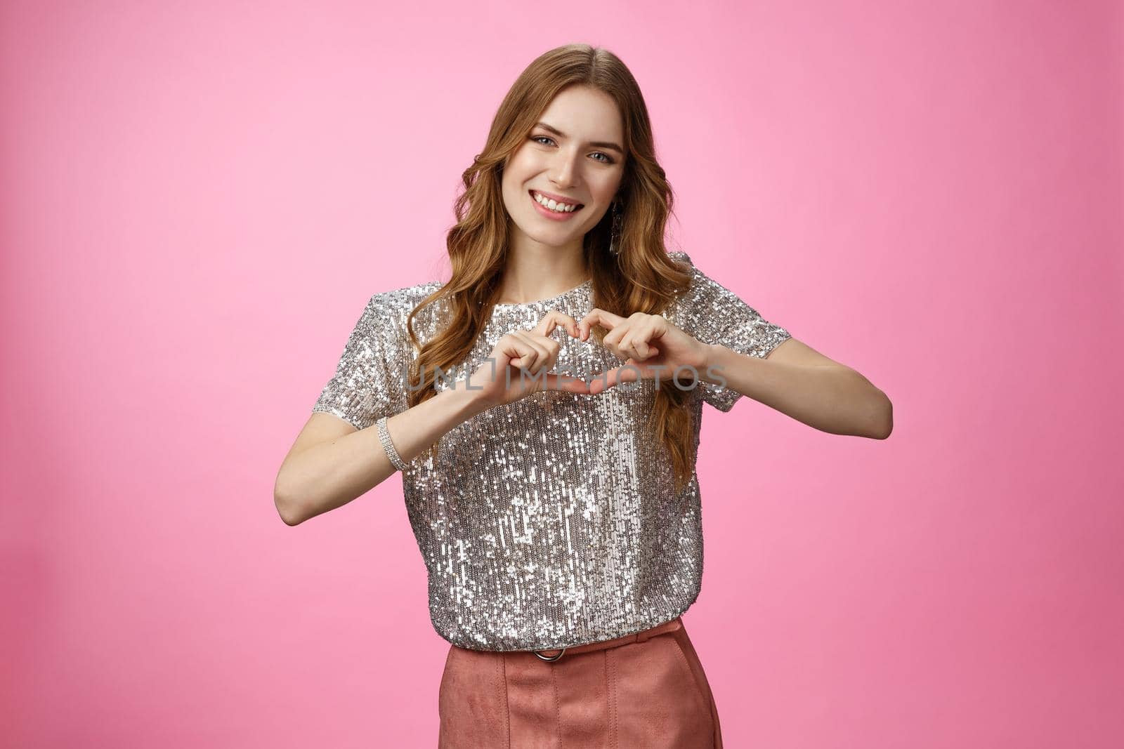 Charming lovely glamour european girlfriend expressing love sympathy afferction smiling cute show heart gesture in love boyfriend adore family relatioship, friendship concept, pink background.