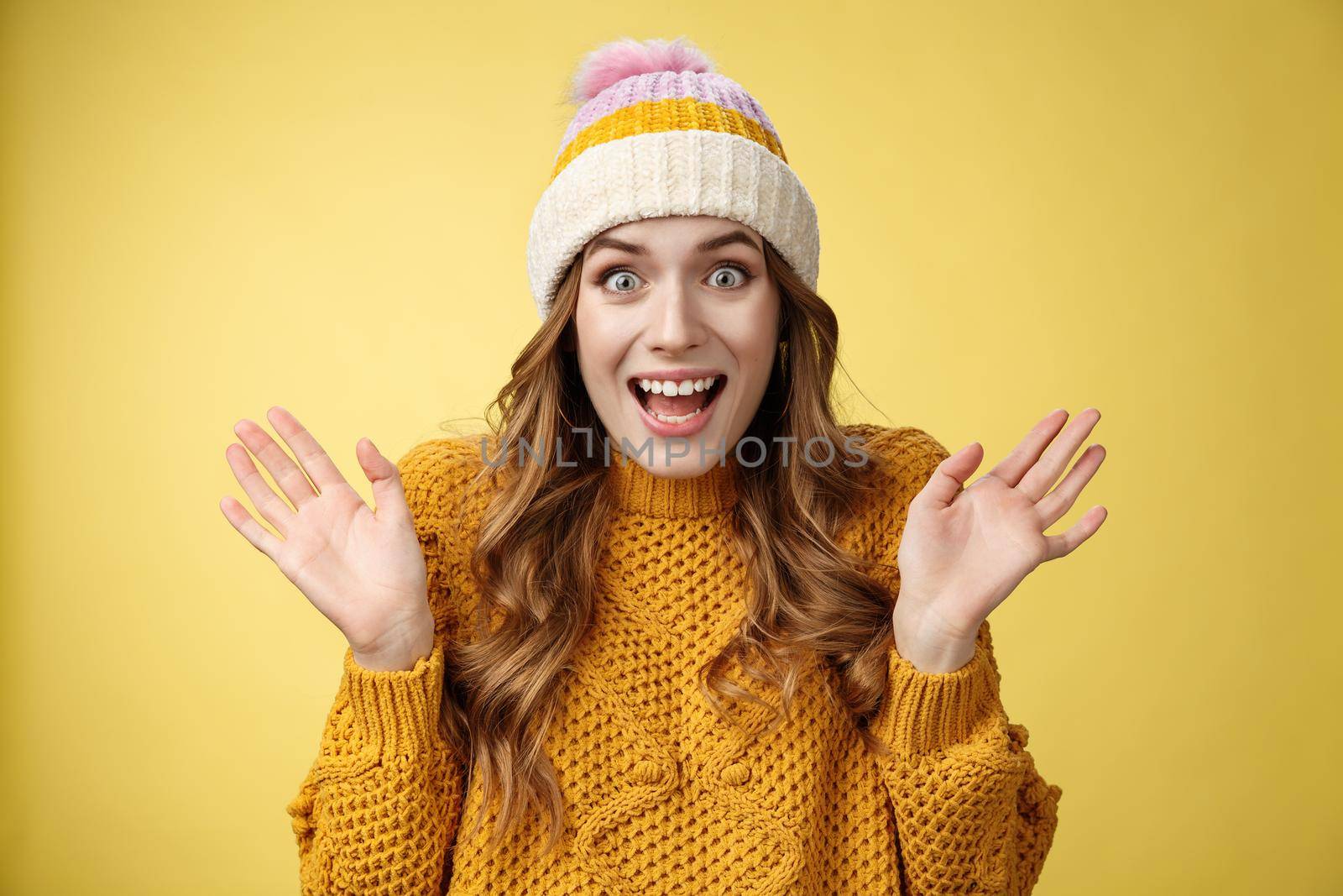 Close-up surprised excited astonished attractive female screaming happily raise hands wondered amazed winning lottery hear awesome perfect news, celebrating smiling broadly, yellow background.