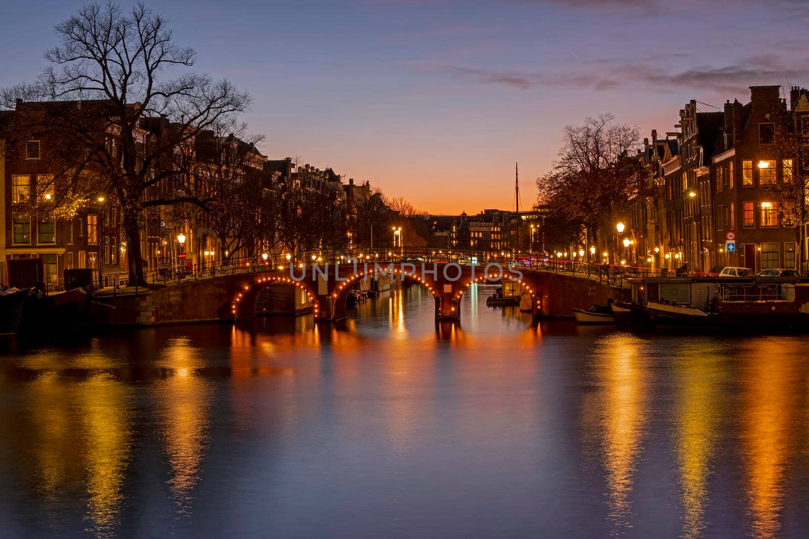 City scenic from Amsterdam at the river Amstel in the Netherlands at sunset