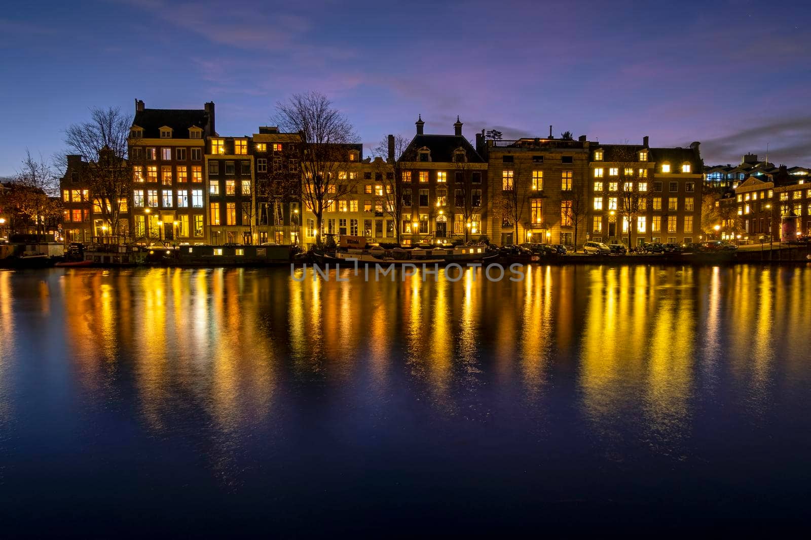 City scenic from Amsterdam at the river Amstel in the Netherlands at sunset