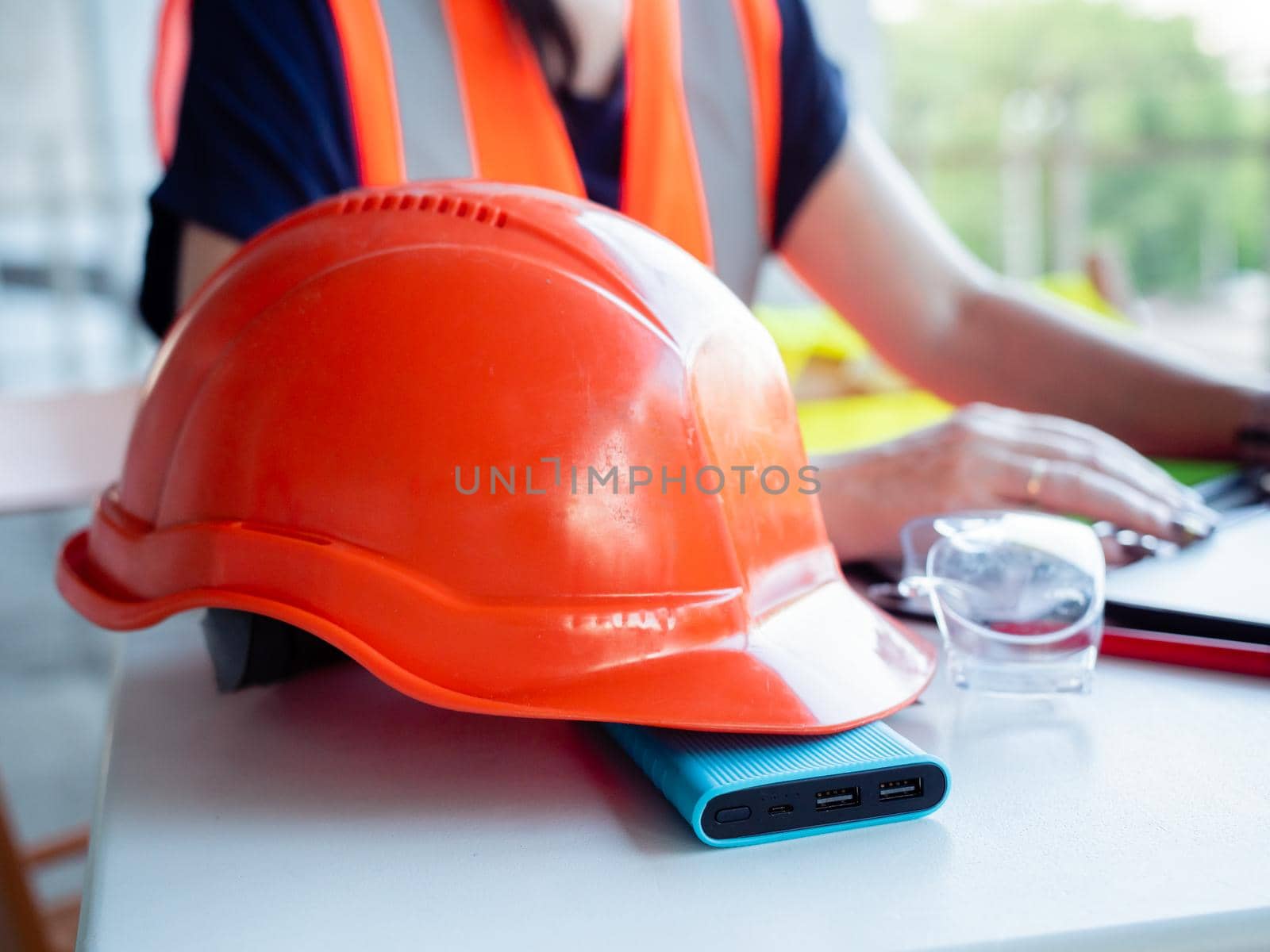 Close-up of a construction safety helmet lies. Woman builder working on a construction site on behind a laptop by Utlanov