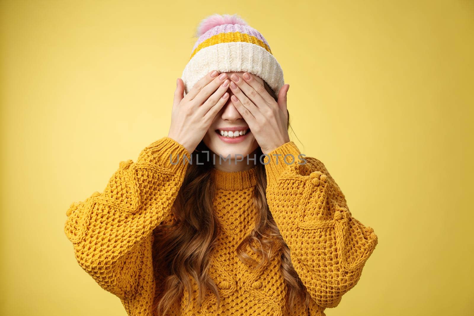 Close-up studio shot charming cute young girl waiting surprise press palms eyes smiling anticipating secret present, standing amused cannot wait gaze awesome gift, birthday party concept.