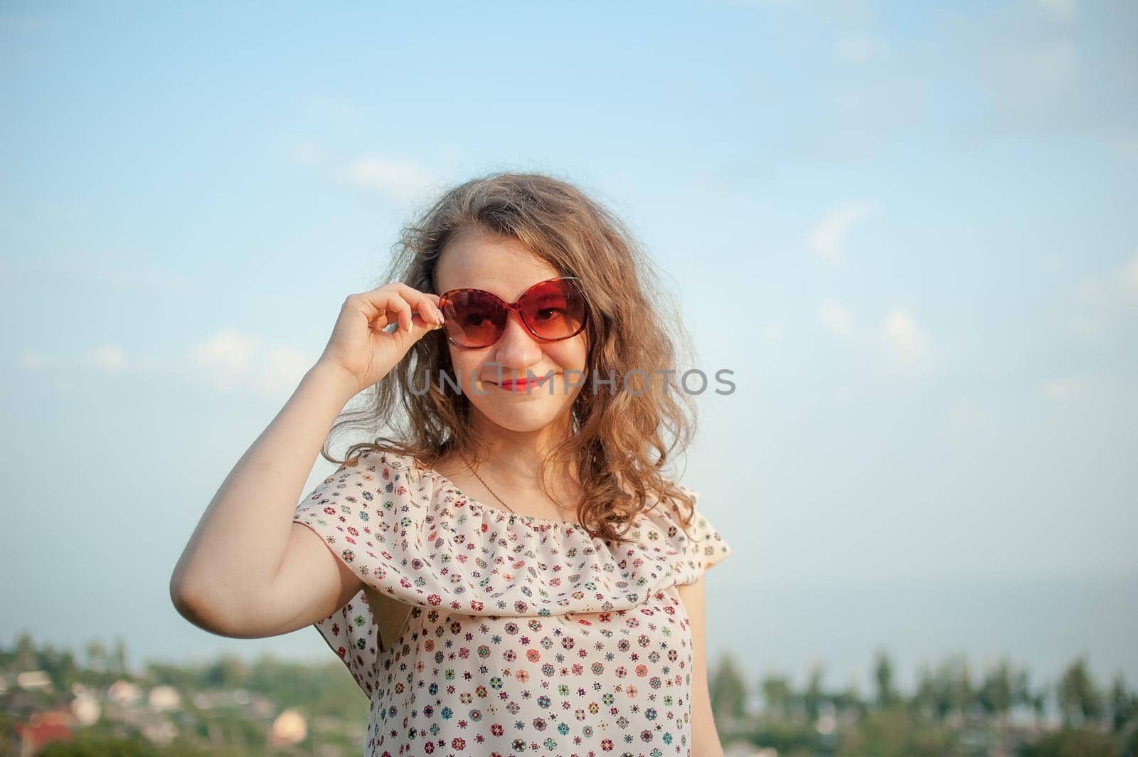 Young girl in dress is having great time during vacation in the summer on sky background in nature, travelling concept.