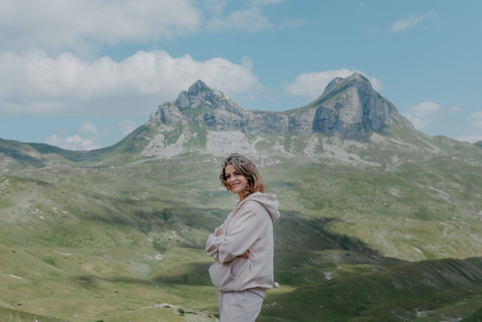 Hiker tourist girl standing on top of the mountain and enjoying valley view. Happy woman with her arms outstretched, freedom and happiness, achievement in mountains by Andrii_Ko