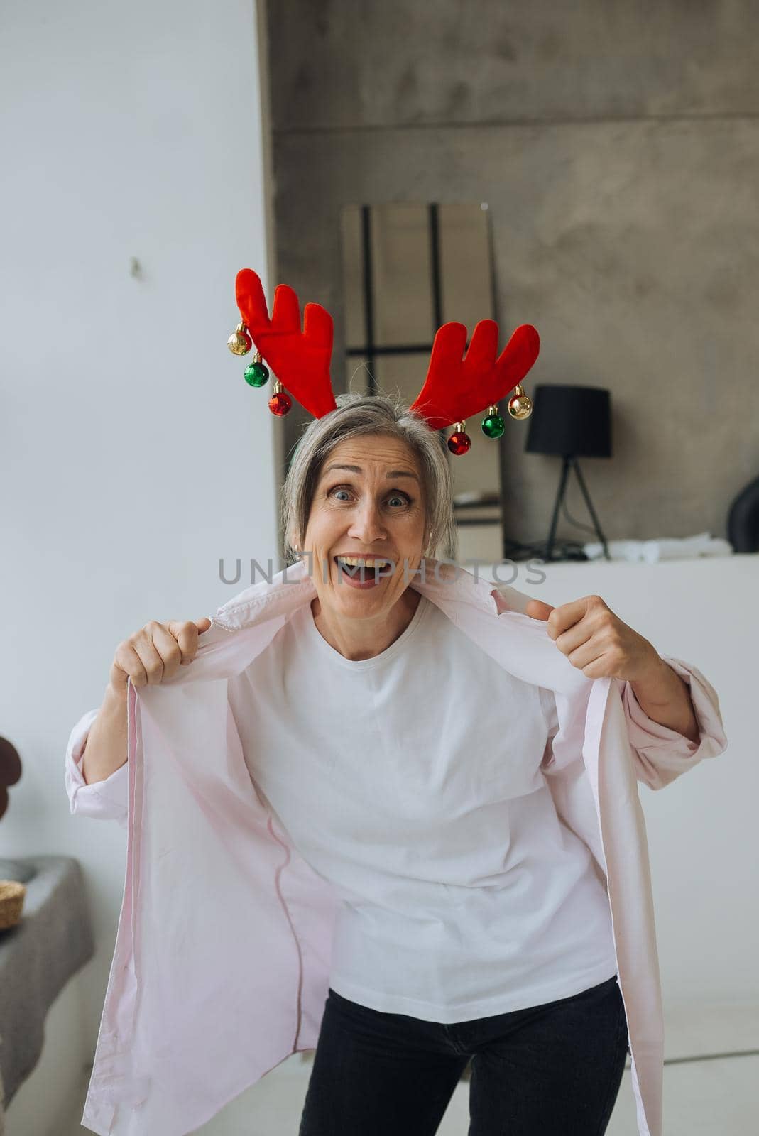 Grandma wearing deer christmas hat, happy smiling face looking at the camera. positive person.