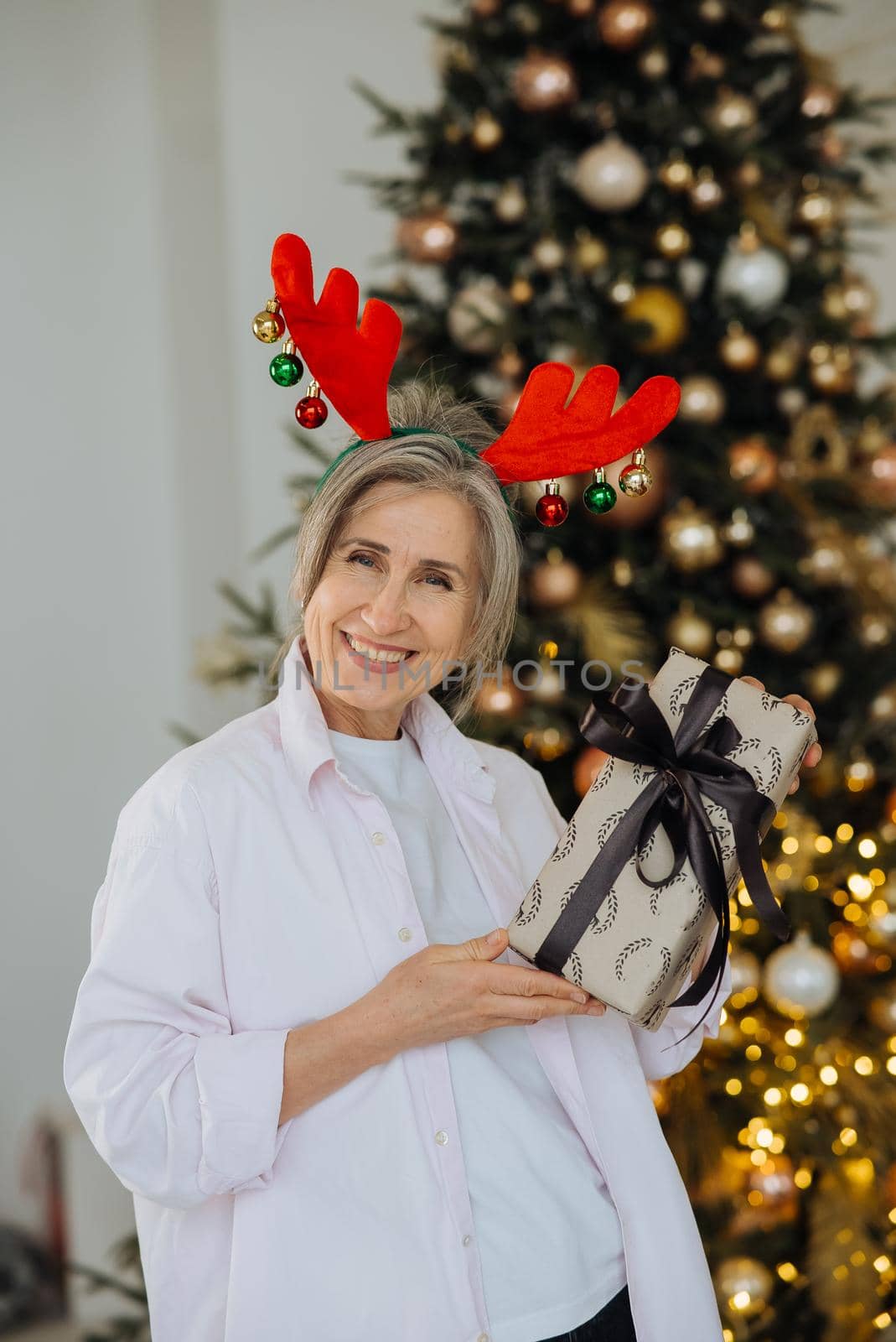 Grandma wearing deer christmas hat, happy smiling face.