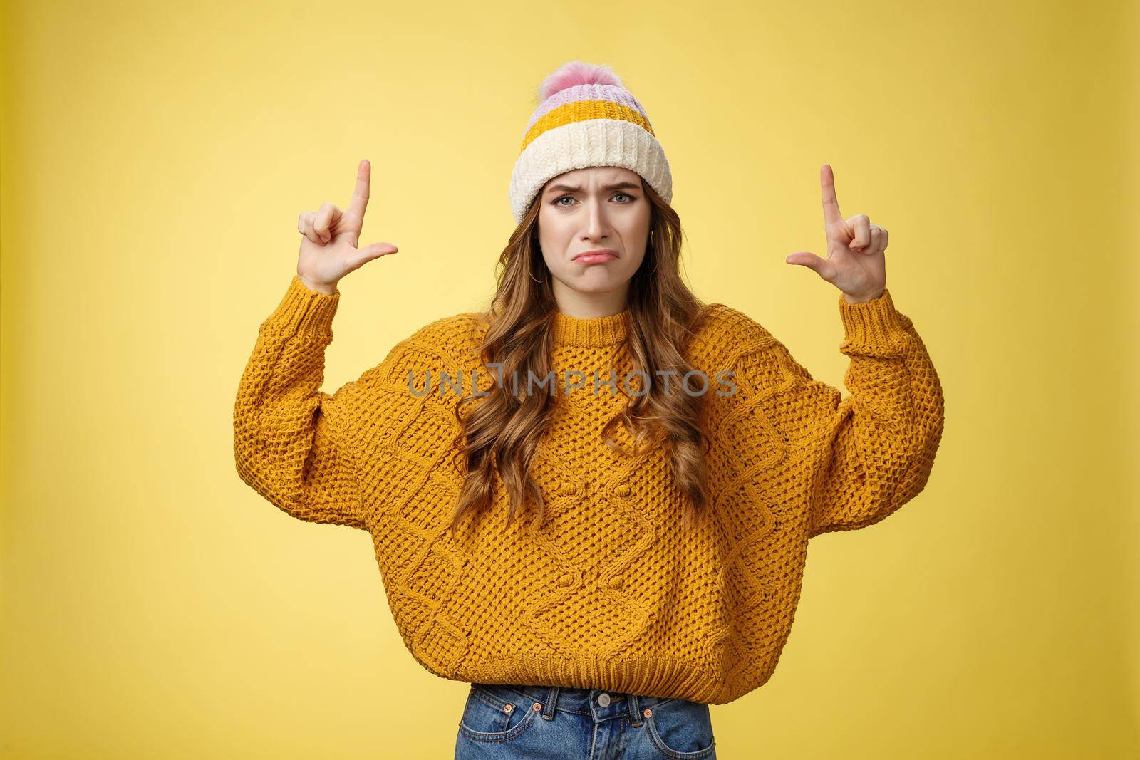Upset whining complaining displeased cute young immature girl raise hands pointing up crying jealous regret wanna buy cool product have no money, standing sad sobbing yellow background.