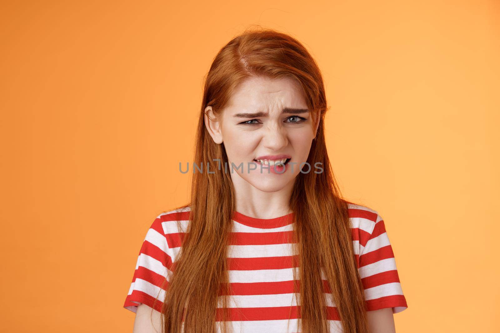 Cute disgusted redhead girl cringe from aversion bad awful smell, frowning grimace disappointed, clench teeth bothered, express dislike and reluctance, feel bad dissatisfied, refuse offer.