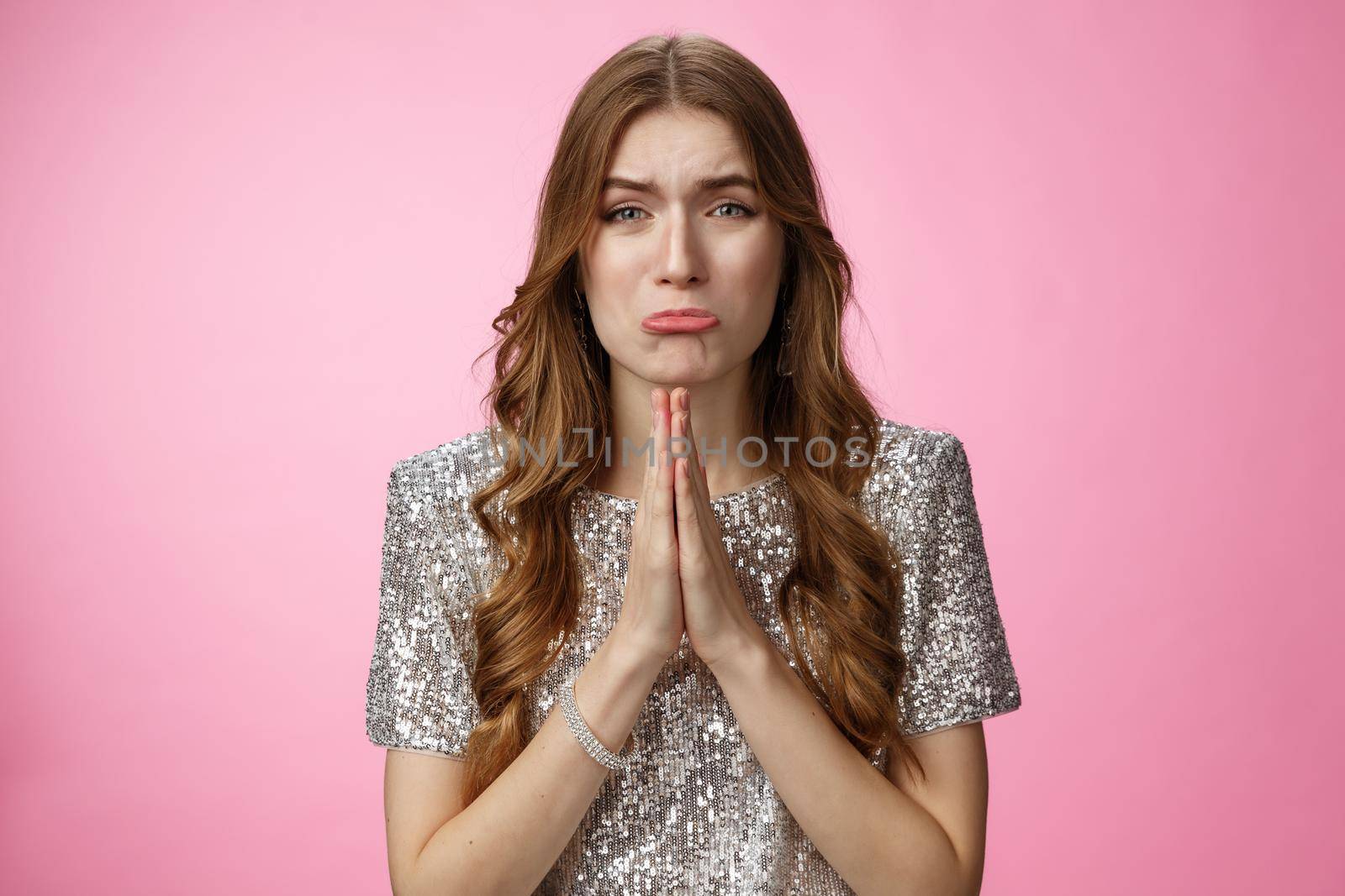 Please beg you. Clingy silly miserable supplicating young cute female curly-haired praying whining about cry press palms together asking please do favor need help, standing pink background.