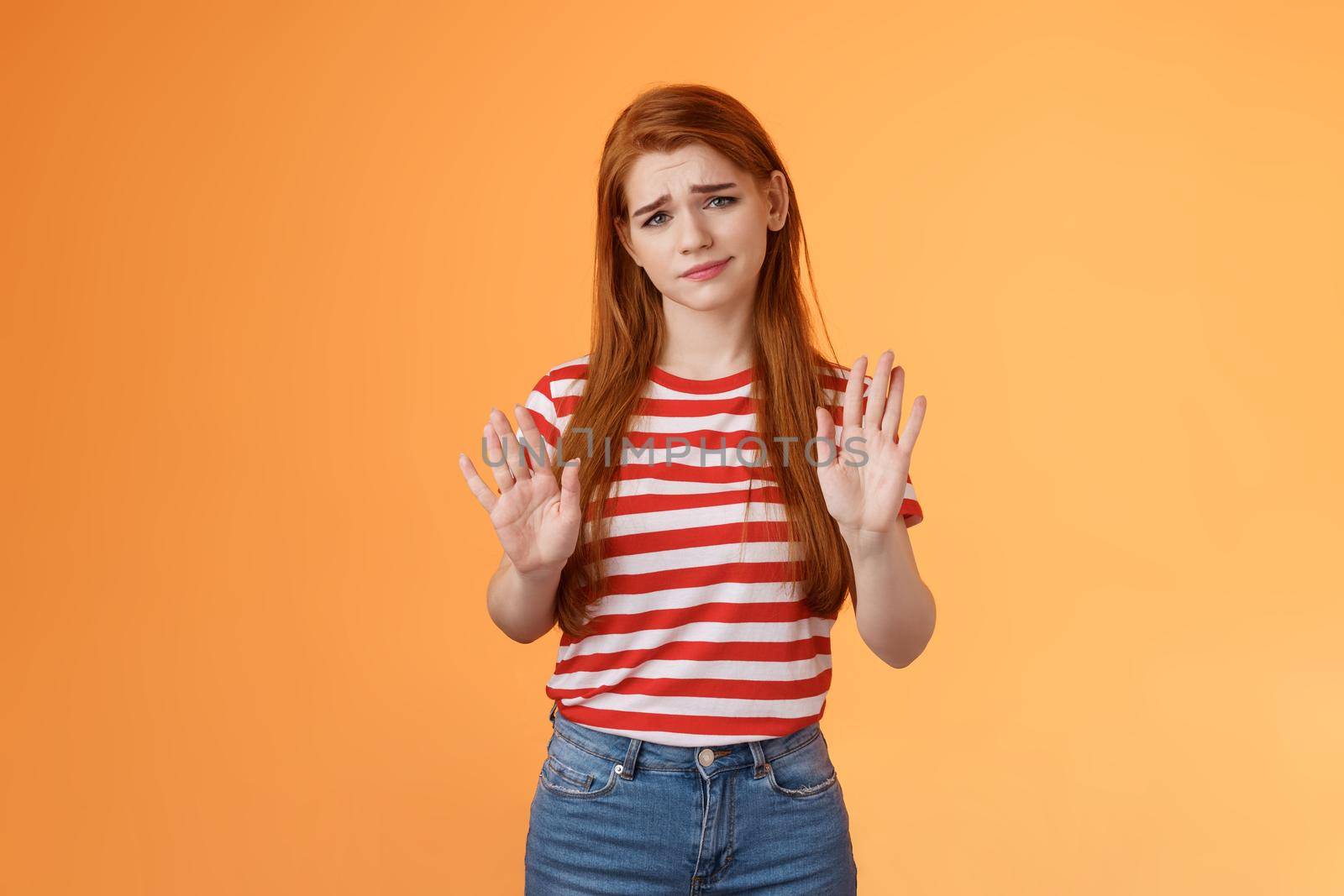 No thanks Im good. Unimpressed redhead female refuse taking party event show stop rejection sign raise palms not gesture, smirk displeased careless, stand uninterested orange background.
