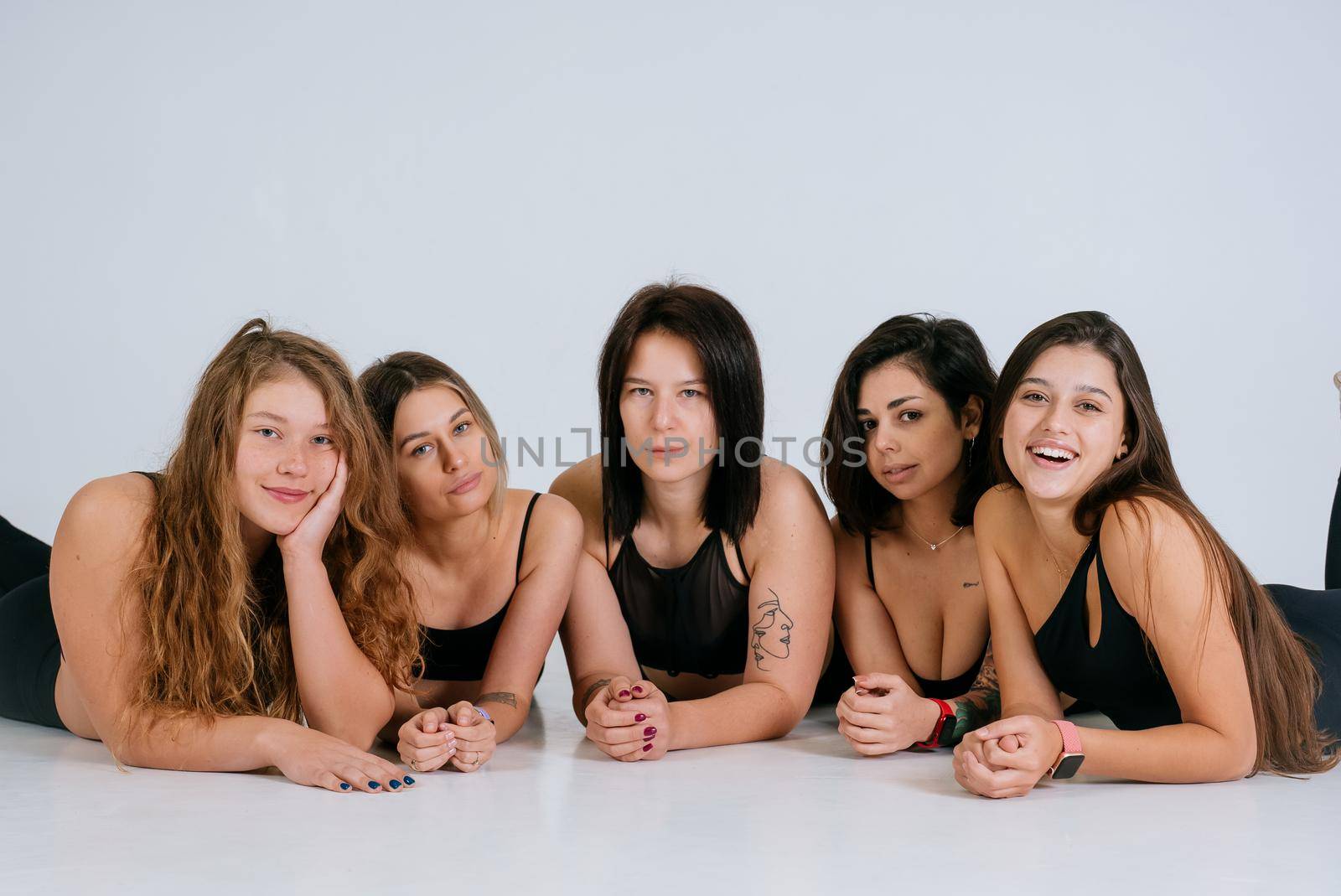 Diverse models wearing comfortable underwear lie on the floor, look at camera having smile and natural unique beauty