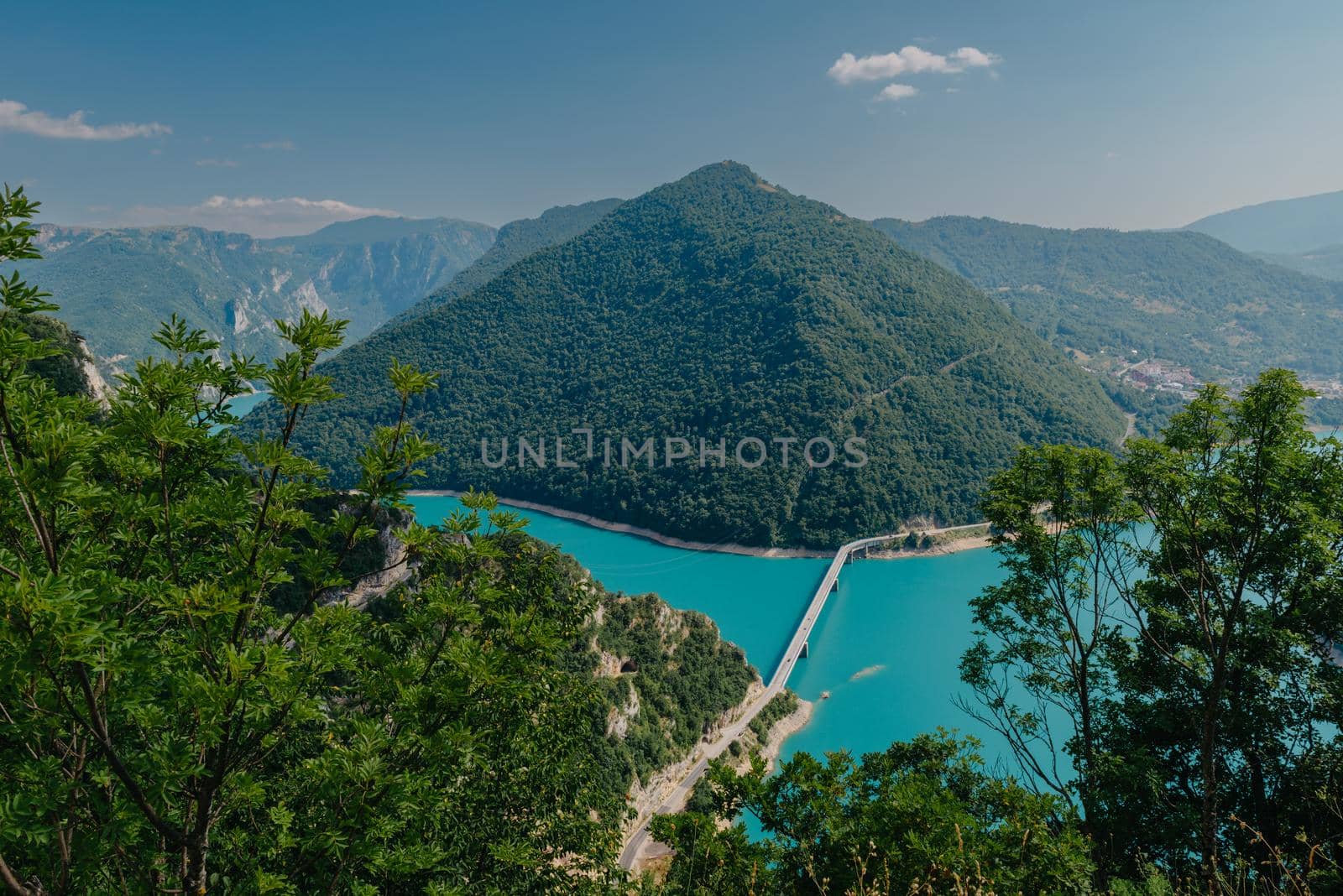 The concept of eco-tourism and active recreation. National Park. Mountain Emerald lake in the wooded mountains. Sunny day in autumn.