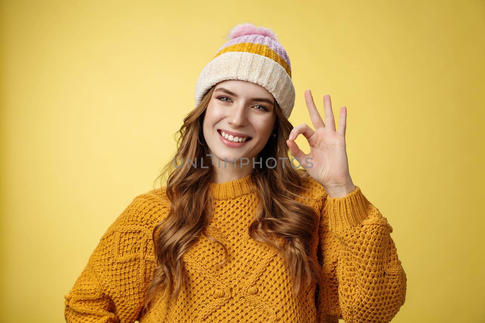 Everything under control. Self-assured optimstic lucky cute girl show okay ok gesture smiling happily having things alright, fine recommend awesome product, pleased standing yellow background.