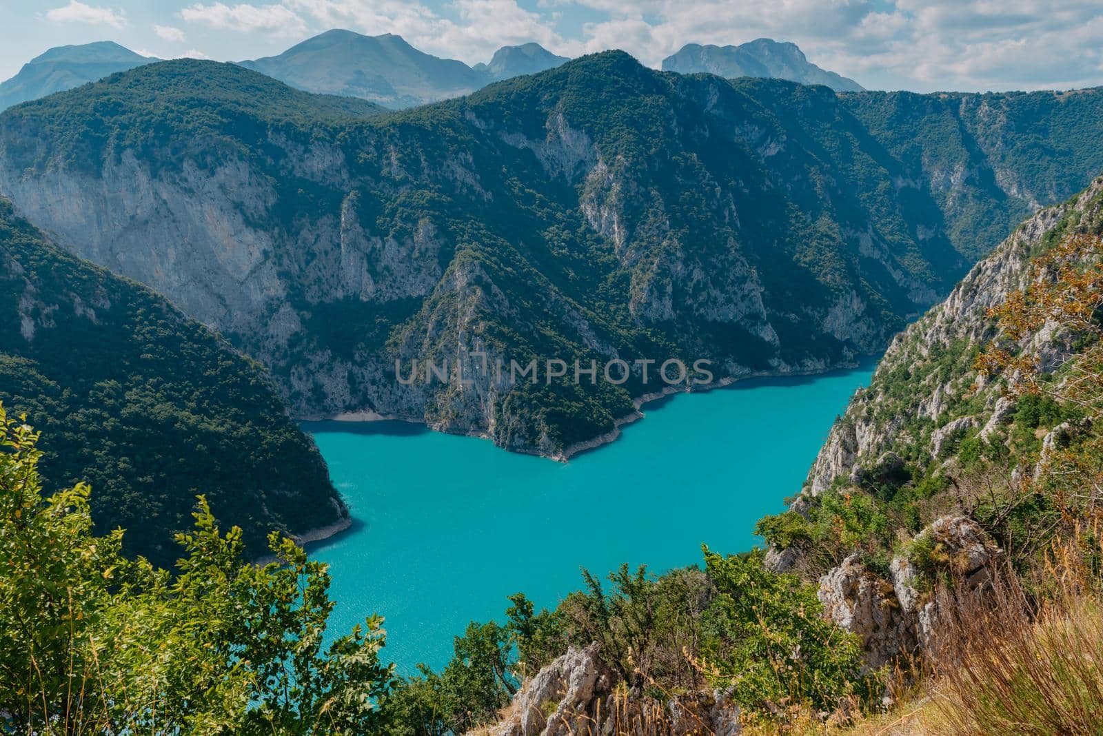 Mountain Emerald lake in the wooded mountains. Sunny day in summer. The concept of eco-tourism and active recreation. National Park by Andrii_Ko