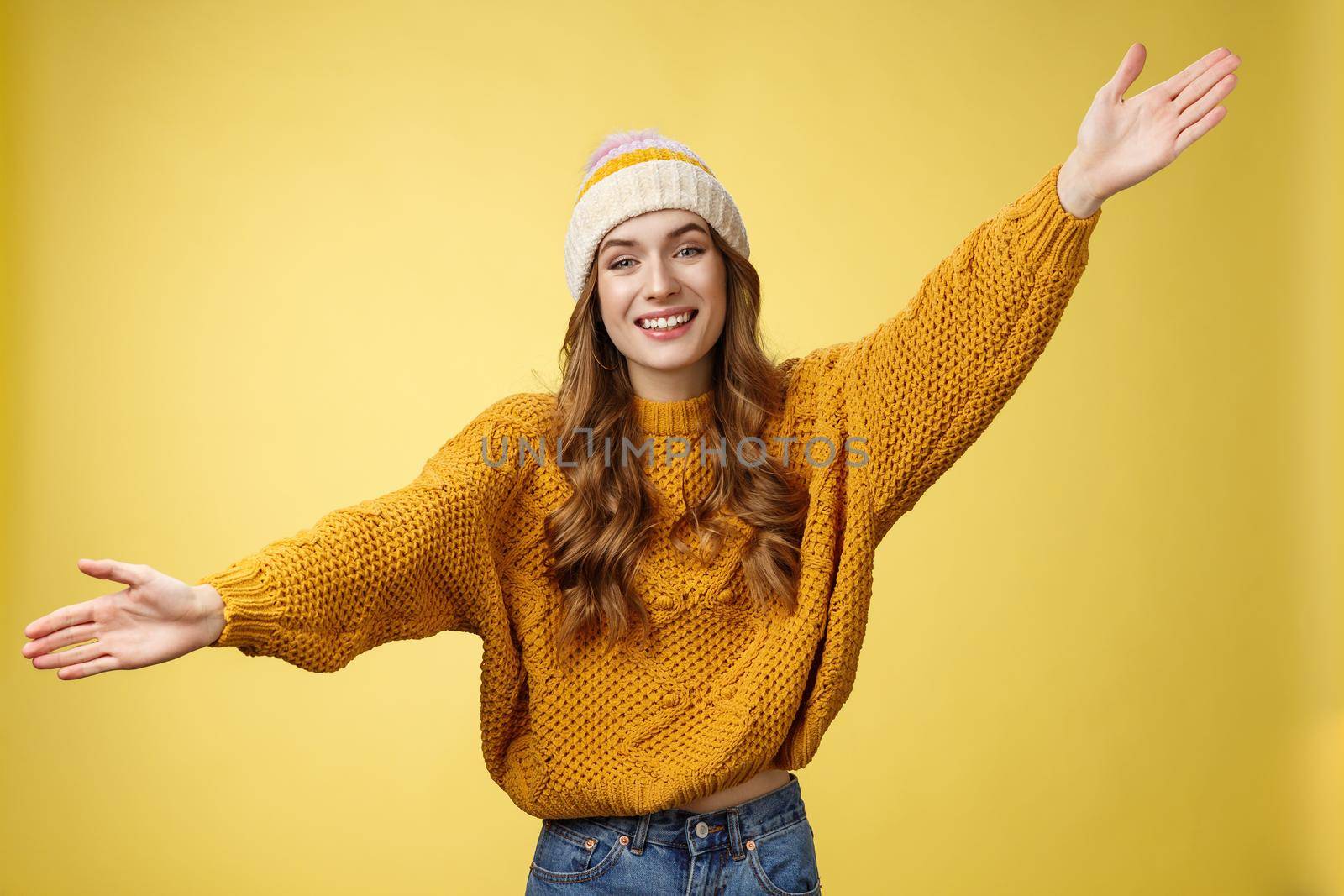 Friendly happy charming smiling cute girl inviting friends joyfully spread hands embracing wanna hug cuddle dear guest grinning cheerful, having fun expressing postivity good mood.