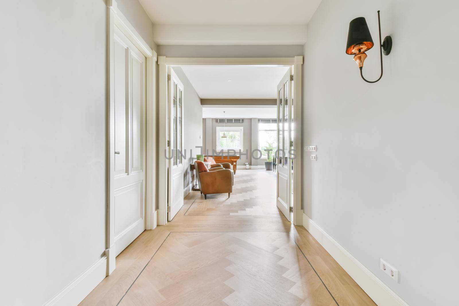 Long stunning hallway with wood flooring and white walls