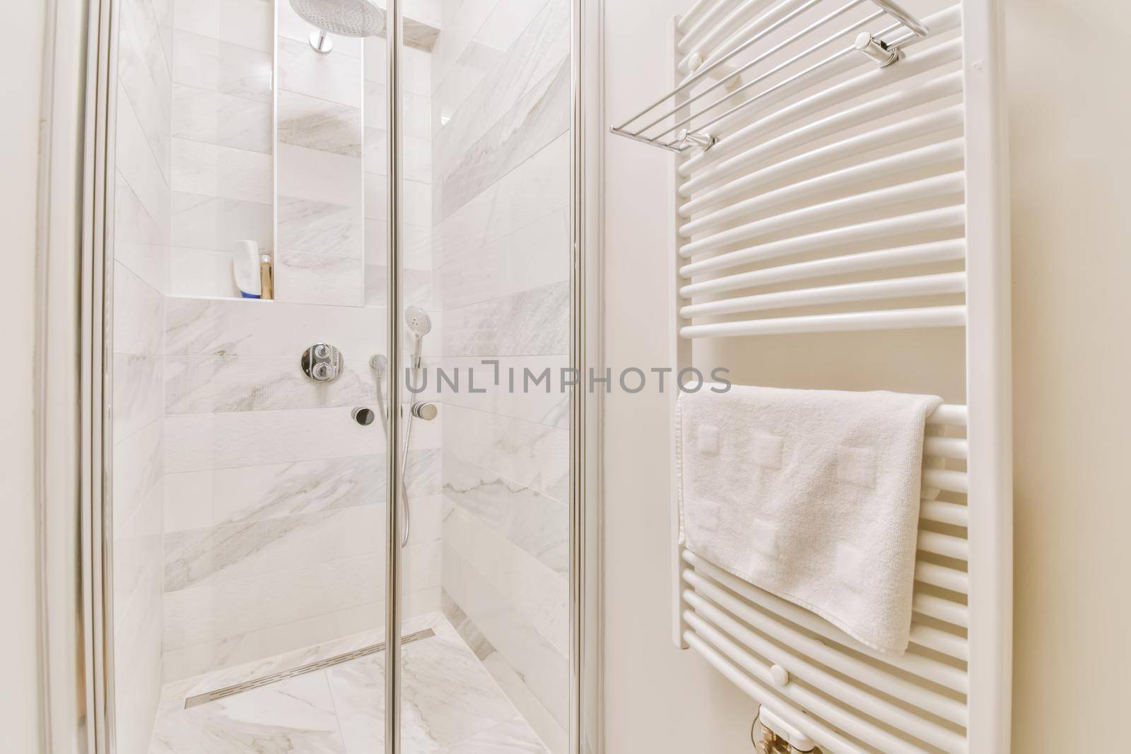 Bright shower cubicle with a radiator and a towel on it