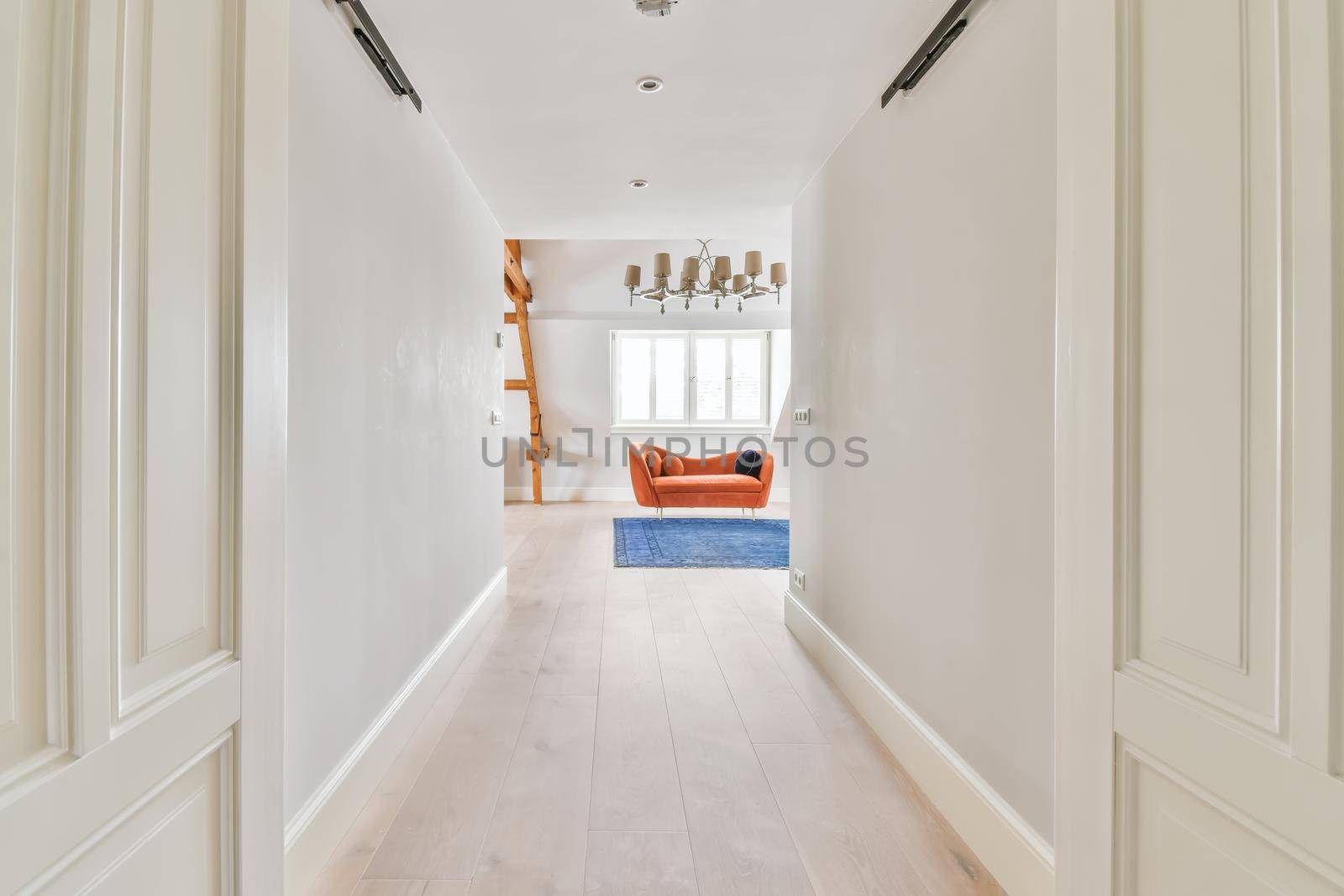 Long stunning hallway with wood flooring and white walls