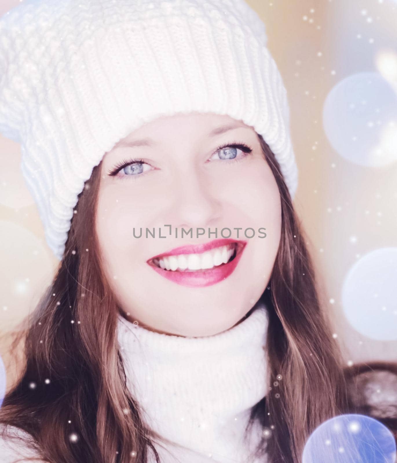 Christmas, people and winter holiday concept. Happy smiling woman wearing white knitted hat as closeup face xmas portrait, snow glitter and bokeh effect.