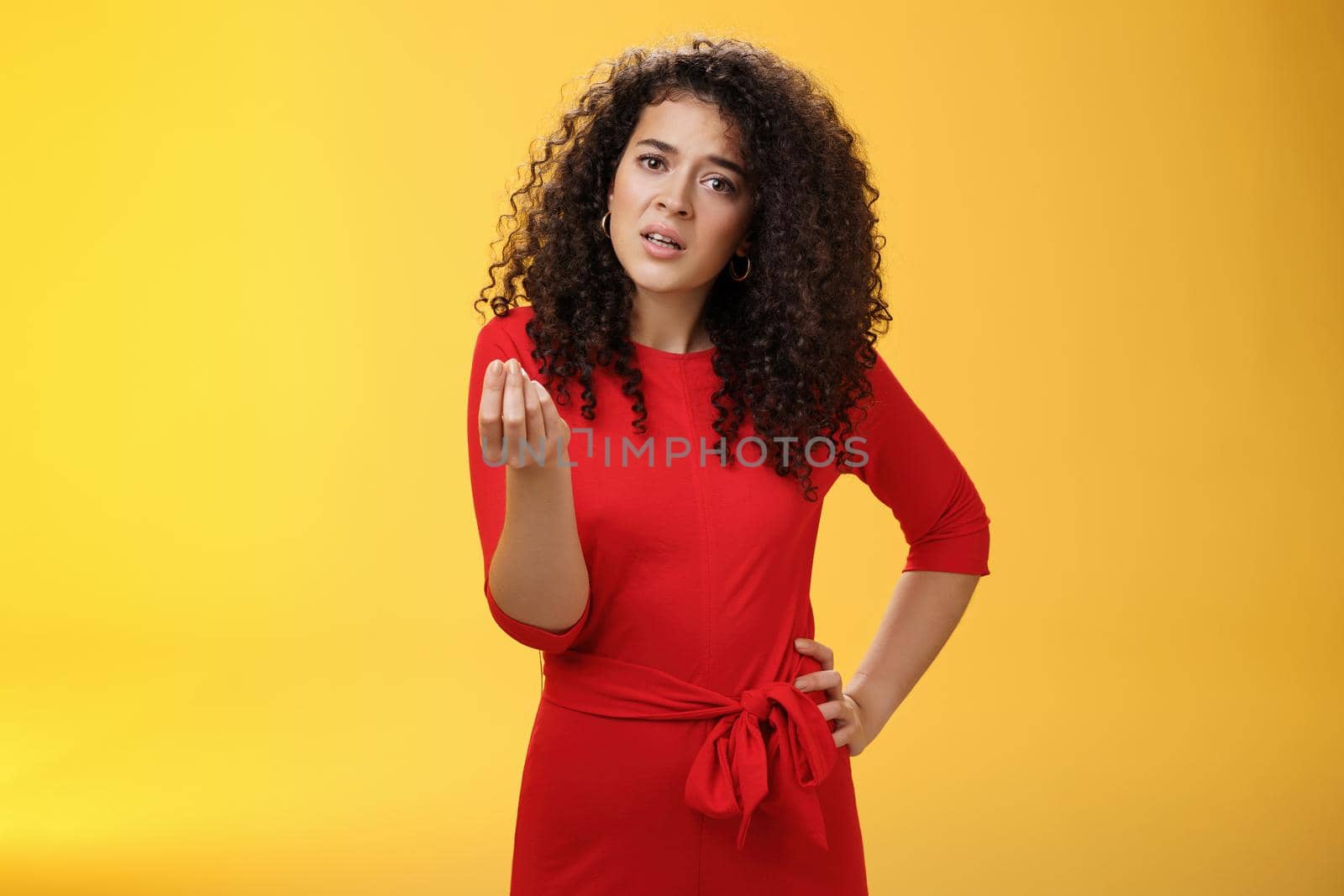 Girl being pissed off arguing ad complaining making italian what do you want gesture looking bothered waiting for explanation as standing annoyed and fed up over yellow background. Negative emotions concept