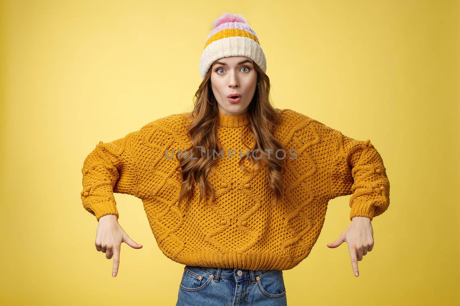 Wow stunning promo. Amused surprised good-looking stylish glamour young woman promoting interesting copy space folding lips amazed widen eyes pointing index fingers down bottom advertisement.