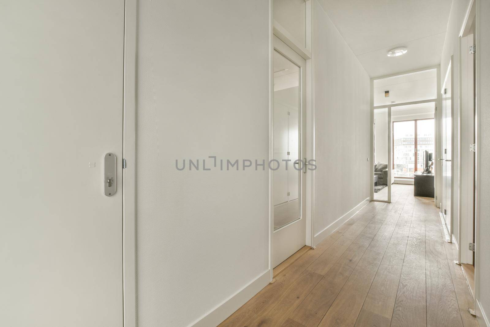 Interior of the narrow corridor with telephone hanging on the wall against stairway in daylight