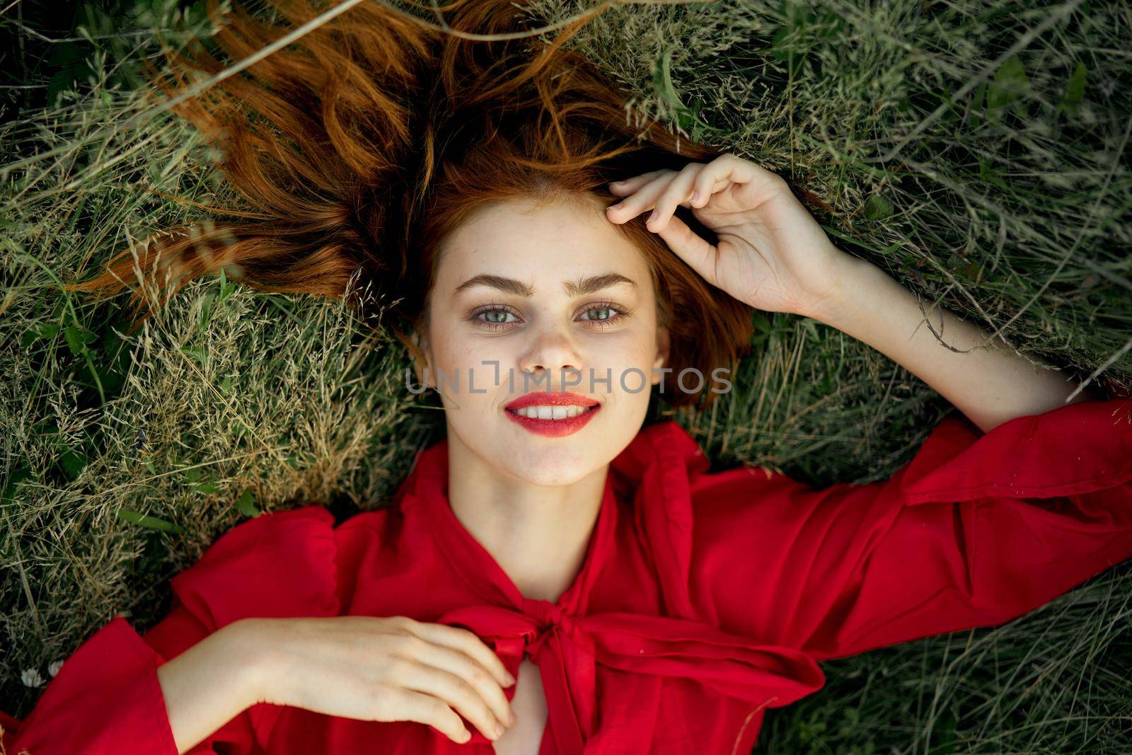 pretty woman in red dress lies on the grass landscape freedom by Vichizh