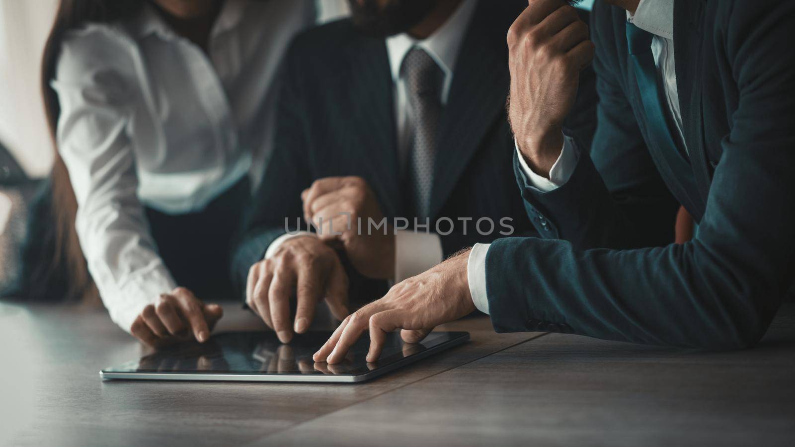 Business Team using digital tablet together. Hands of business people touching screen of electronic device. Toned image. Close up shot. Side view.