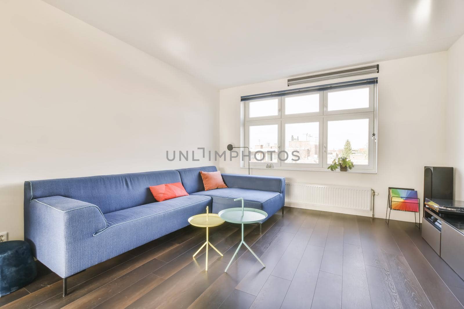 Attractive living room with blue sofa and glass blue and yellow coffee table