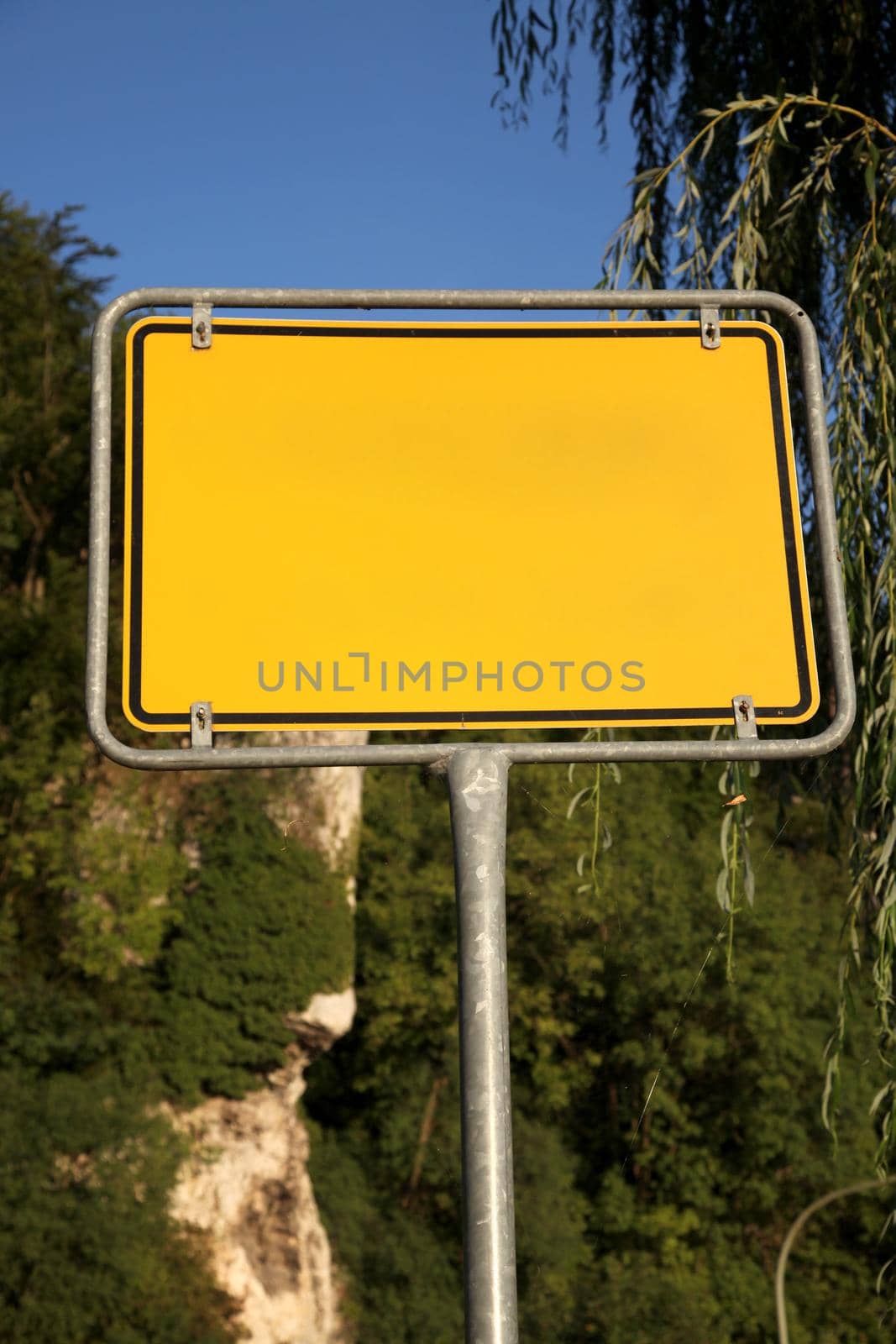 Yellow road sign on a background of trees - Photo