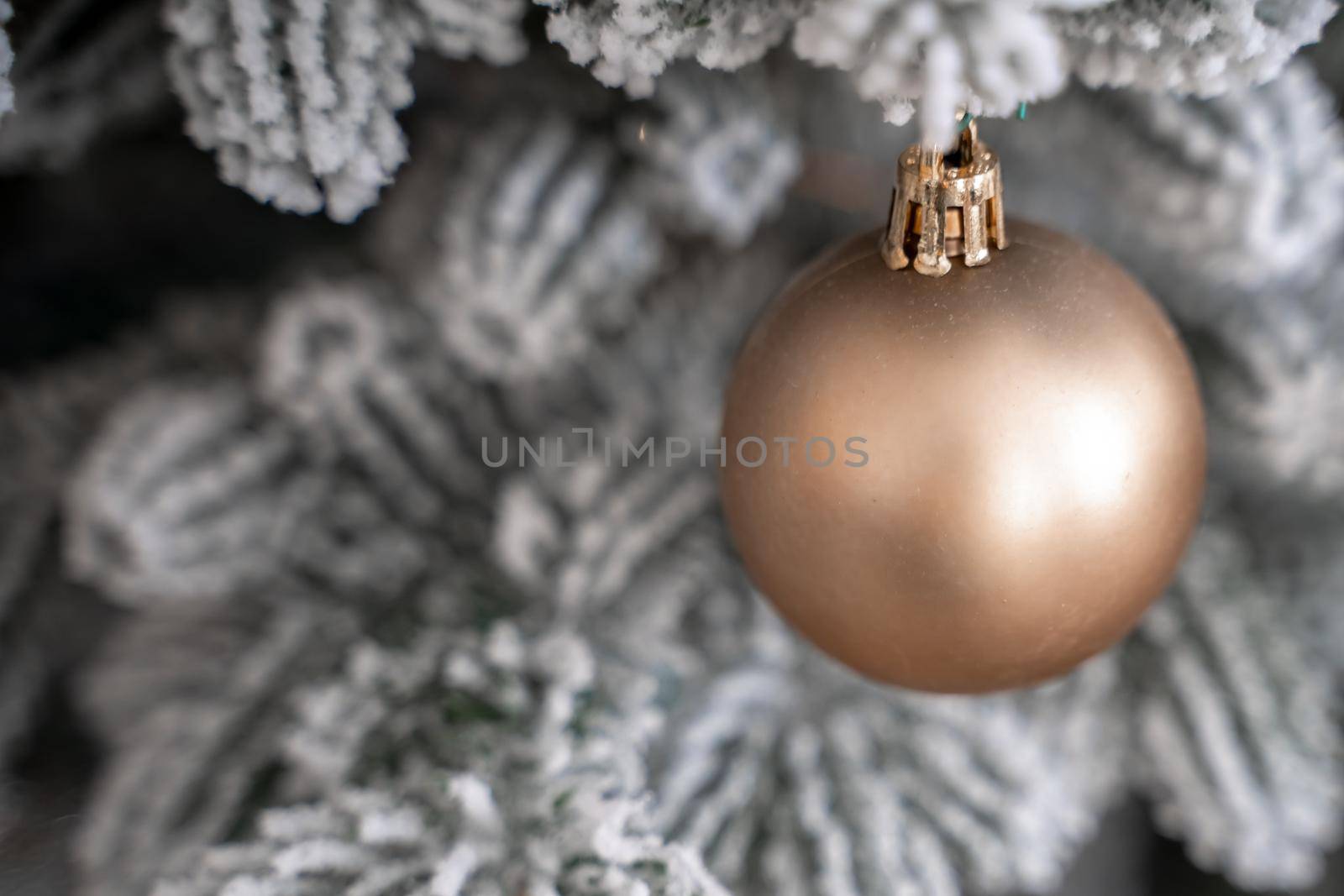 Close-up of a festively decorated outdoor Christmas tree with balls on a blurred sparkling fairy background. Defocused garland lights, bokeh effect