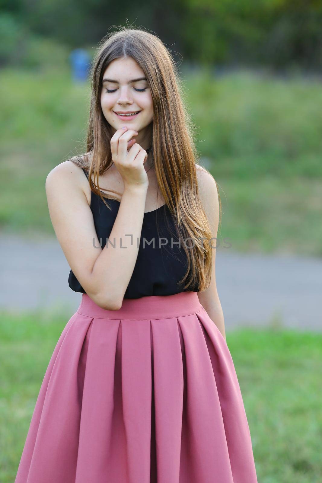 Woman with long hair and beautiful eyes on a green background shows the different human emotions. Lady portrays happy wishes