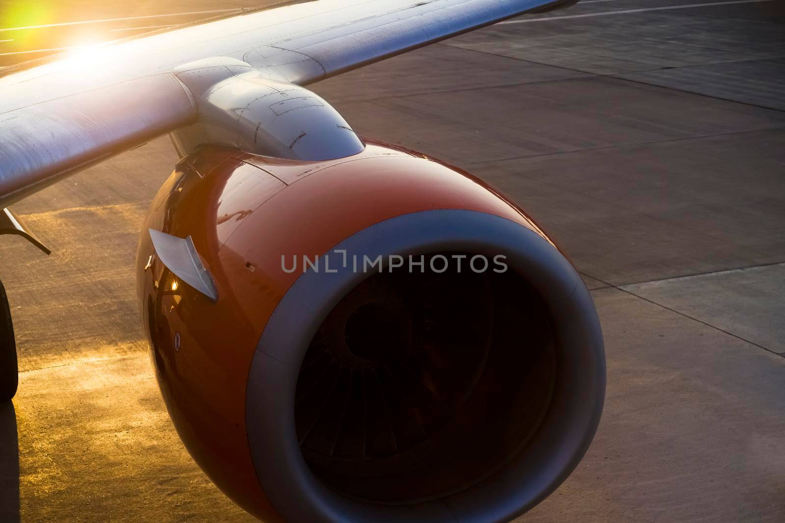 Airplane with a turbine on the runway in the light of the sun.