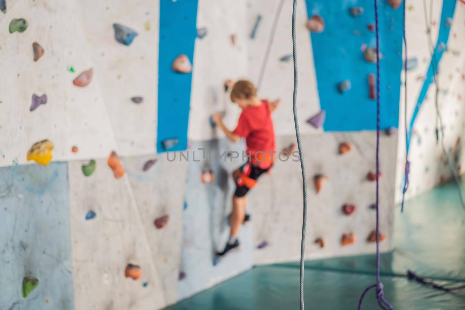 Boy at the climbing wall without a helmet, danger at the climbing wall.