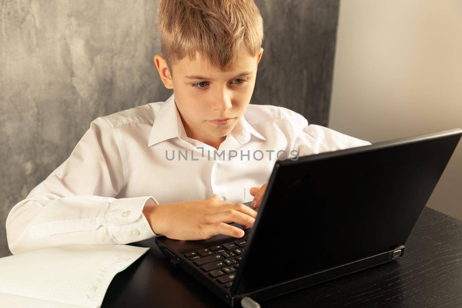 The boy receives education remotely using a computer. Back to school. High quality photo