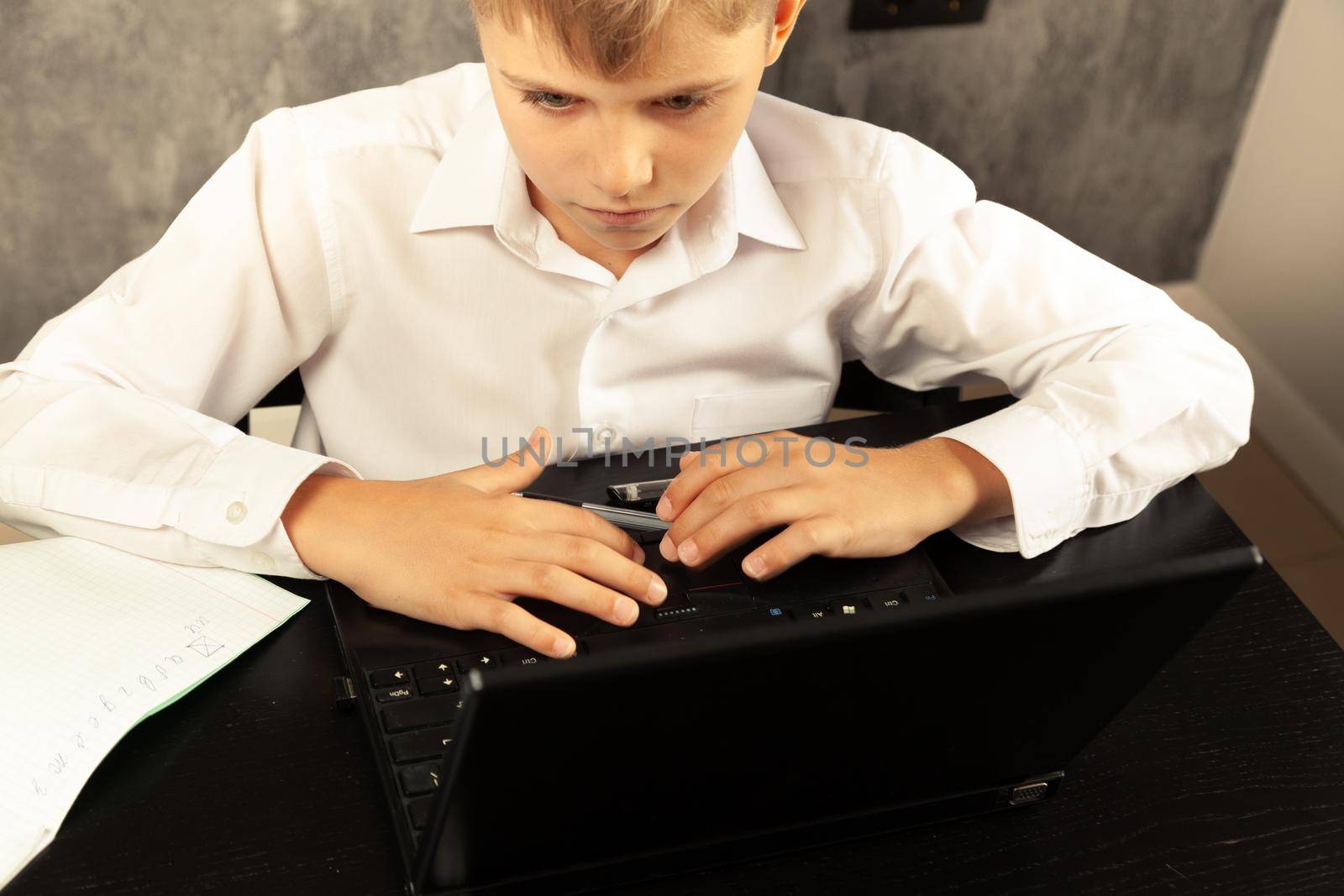 The boy is studying at the computer. Back to school. High quality photo