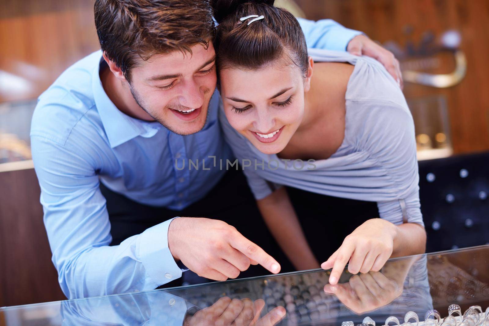 happy young couple in jewelry store by dotshock