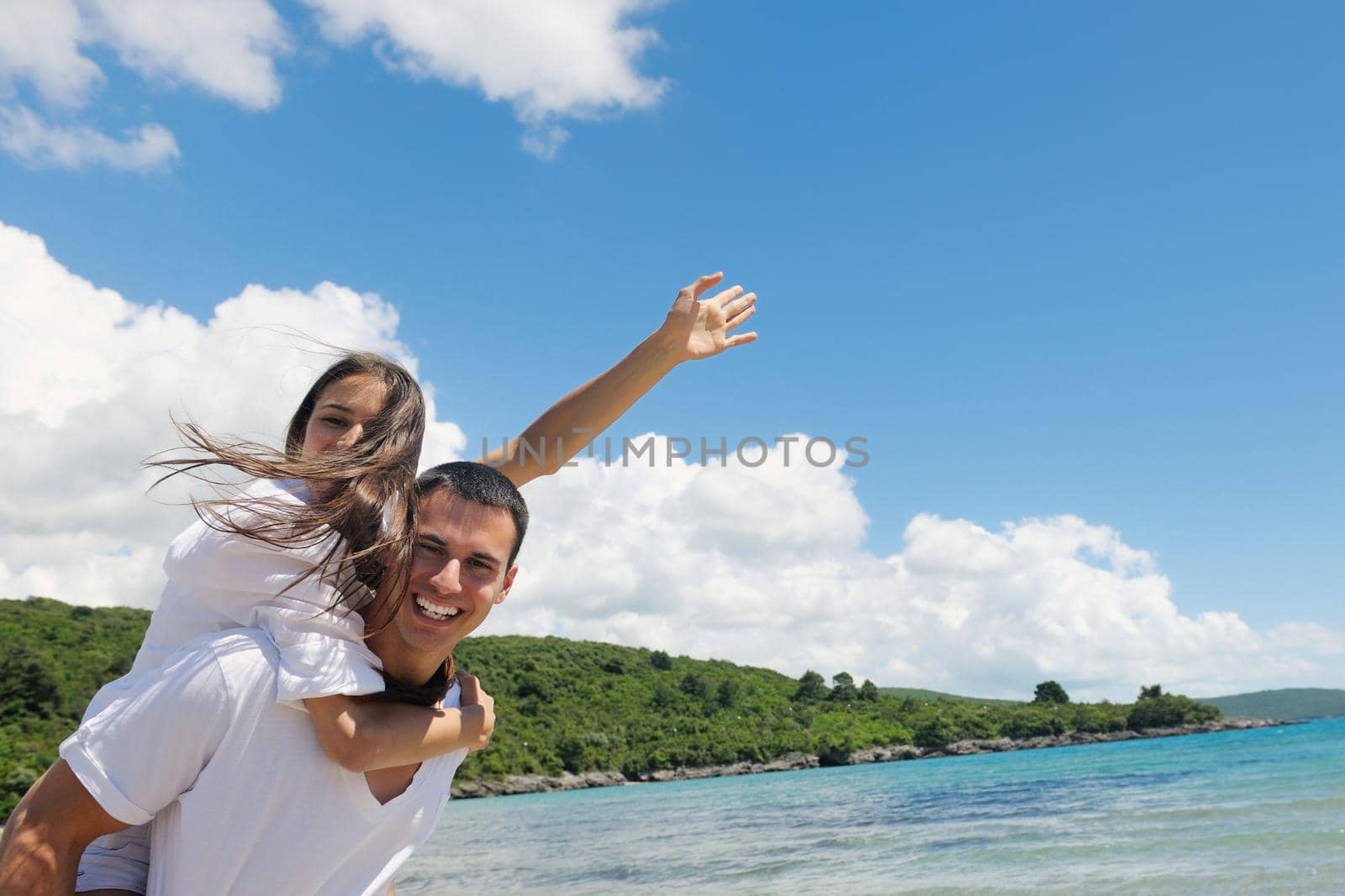 happy couple have fun on the beach by dotshock