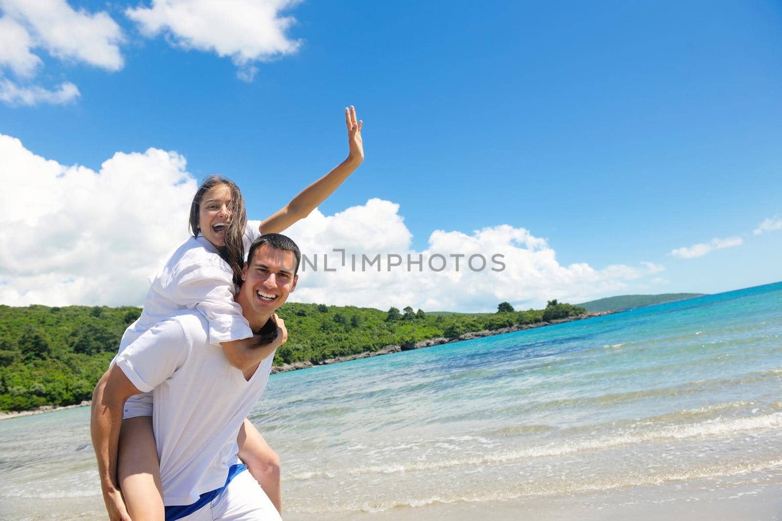 happy couple have fun on the beach by dotshock