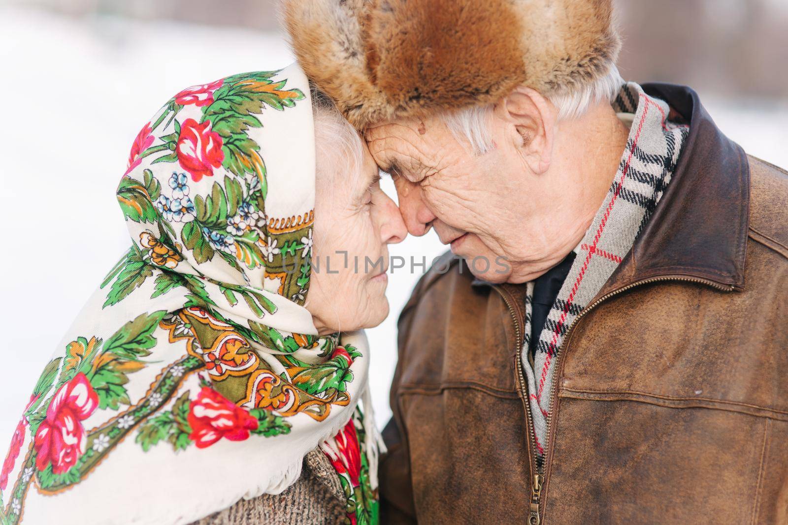 Portrait of happy senior couple. Elderly woman kiss her husband in weighty. old couple walking in the park in winter time. Happy family. Gold wedding.