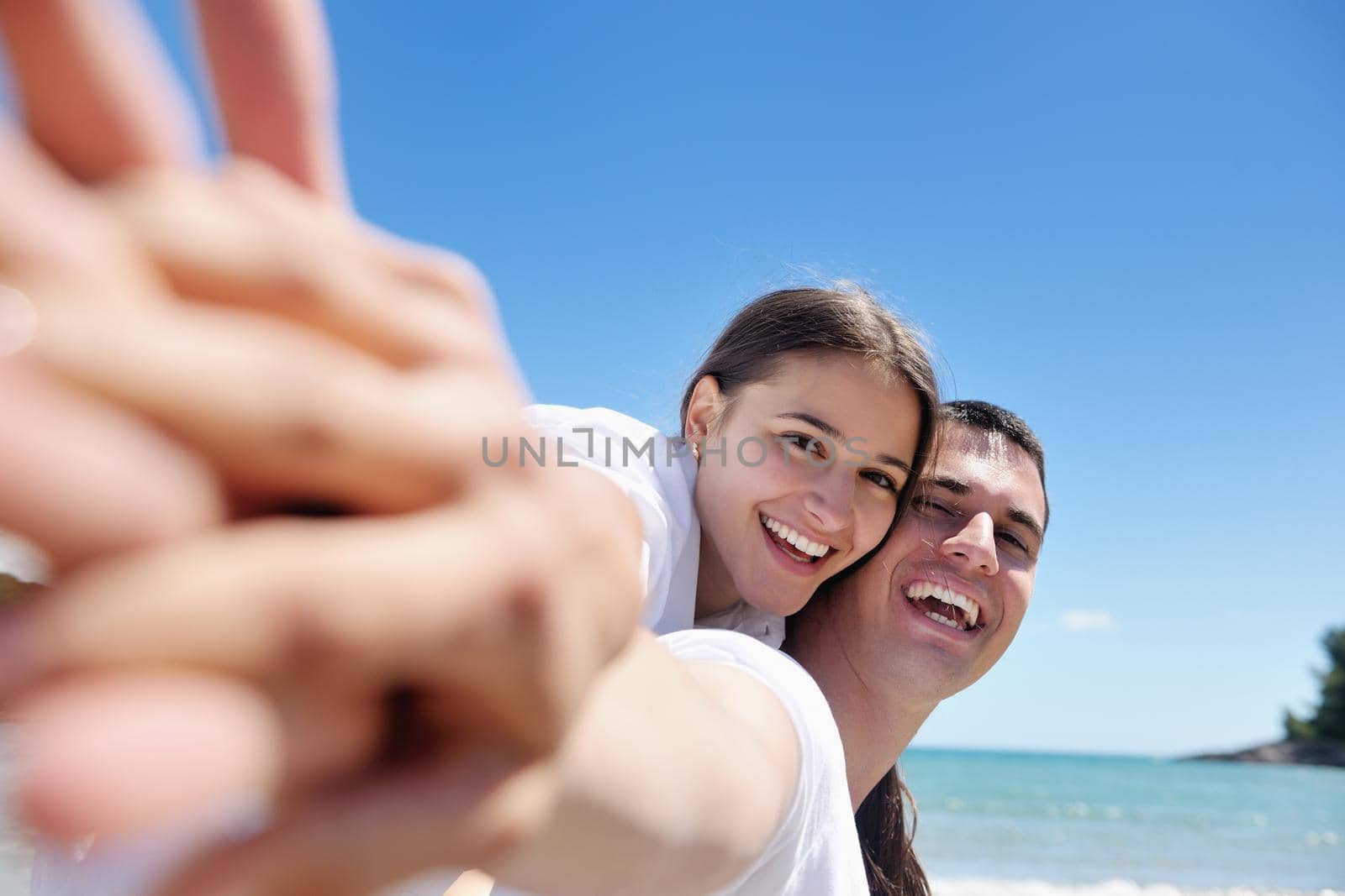 happy couple have fun on the beach by dotshock