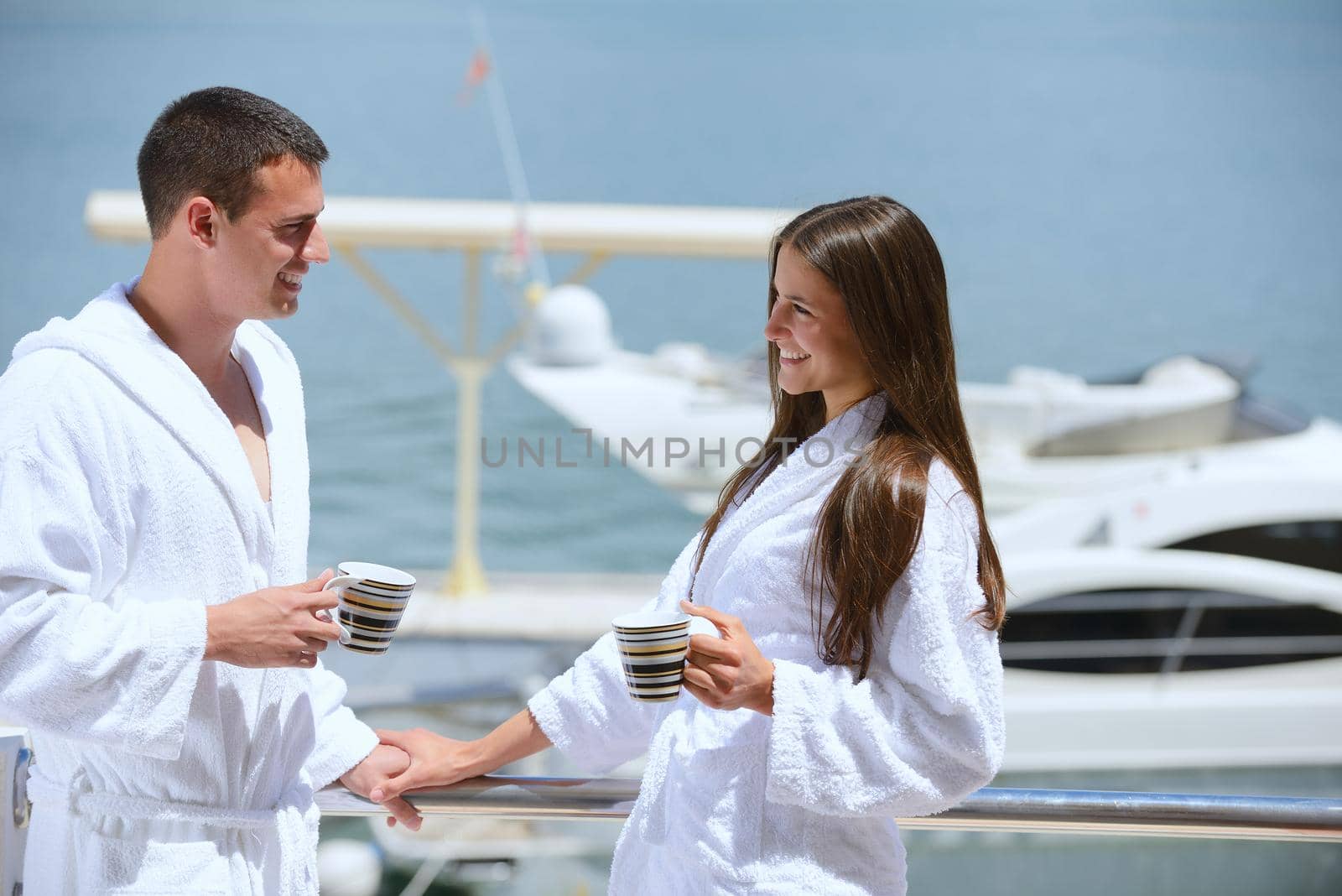 Romantic young couple spending time together and relaxing on yacht