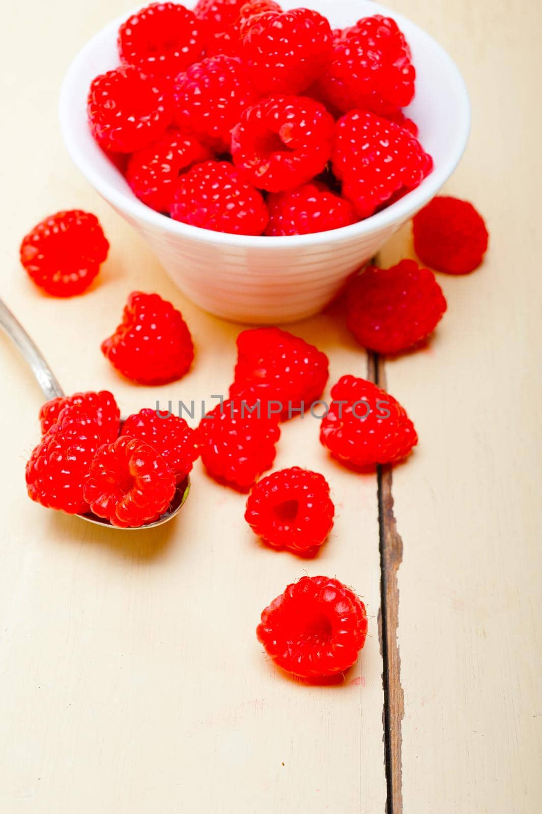 bunch of fresh raspberry on a bowl and white table by keko64